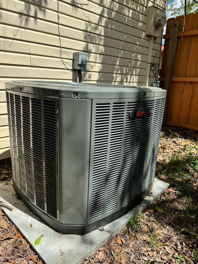details with fence, electric meter, and central AC unit