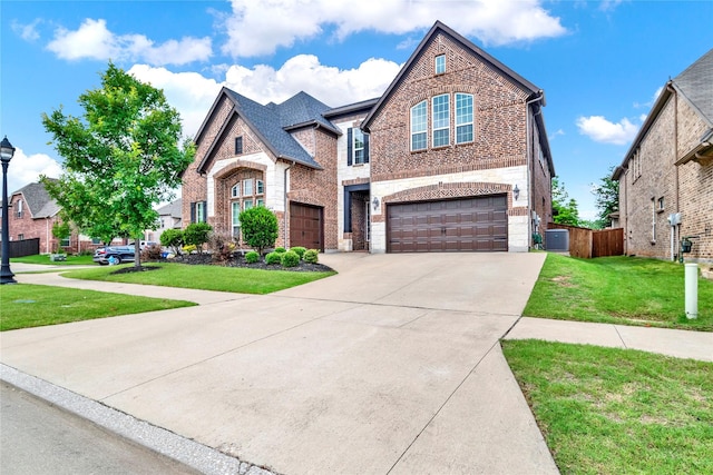 12810 Avanti Dr, Frisco, TX 75035 - view of front of property with stone siding, a front yard, brick siding, an attached garage, and driveway