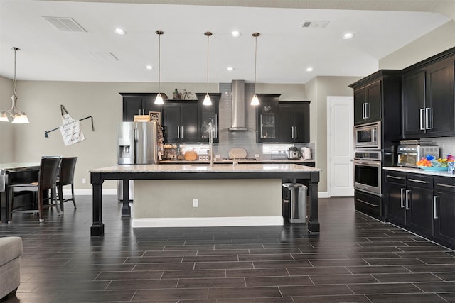 12810 Avanti Dr, Frisco, TX 75035 - kitchen with dark cabinetry, appliances with stainless steel finishes, a sink, and light stone counters