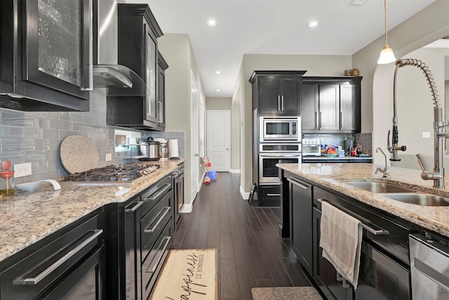 12810 Avanti Dr, Frisco, TX 75035 - kitchen with light stone counters, visible vents, a center island with sink, a lit fireplace, and dark wood-style floors