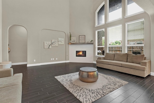 12810 Avanti Dr, Frisco, TX 75035 - living area featuring a high ceiling, arched walkways, recessed lighting, baseboards, and dark wood-style floors