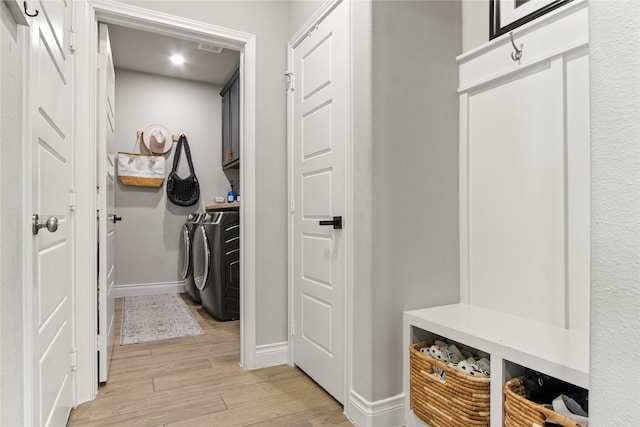 mudroom with washer and dryer, baseboards, and light wood-style floors