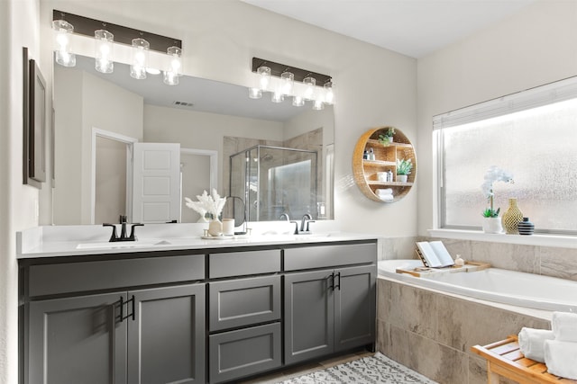 full bath with a shower stall, double vanity, a bath, and a sink