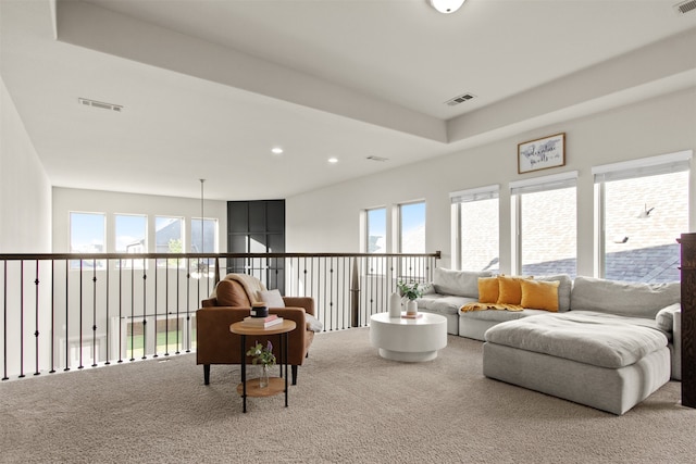 living area featuring a raised ceiling, visible vents, recessed lighting, and carpet flooring