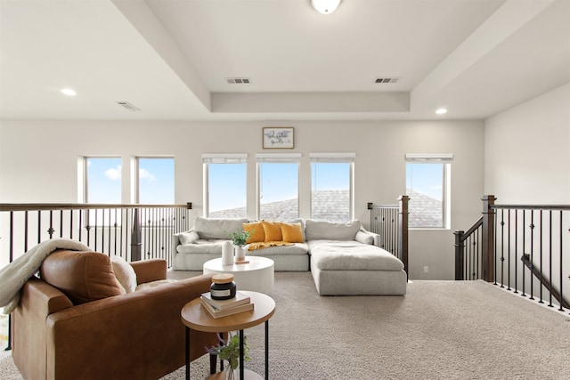 carpeted living room with recessed lighting, visible vents, and a raised ceiling