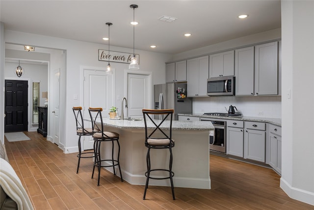 kitchen with visible vents, dark wood finished floors, decorative backsplash, gray cabinetry, and appliances with stainless steel finishes