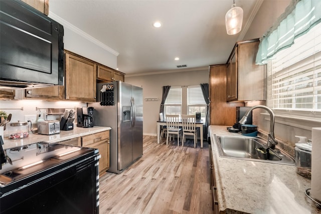 kitchen with black appliances, light wood finished floors, a sink, visible vents, and crown molding