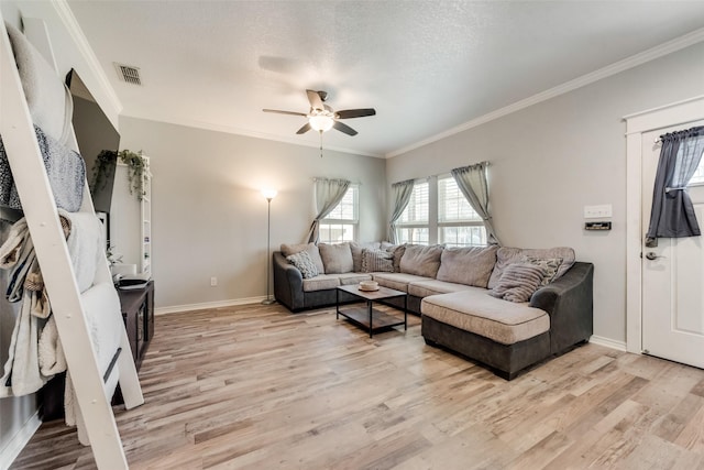 living room with ornamental molding, ceiling fan, light wood finished floors, and baseboards
