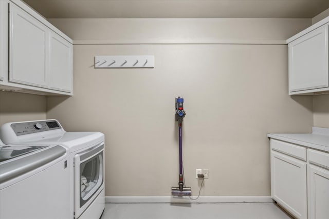 laundry room with independent washer and dryer and cabinet space