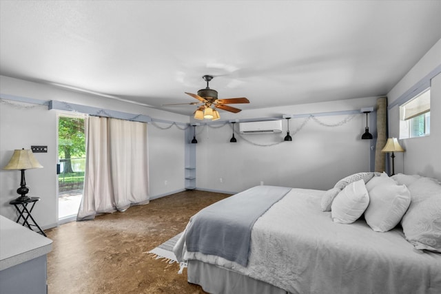 bedroom featuring a wall mounted air conditioner, concrete flooring, access to exterior, and baseboards