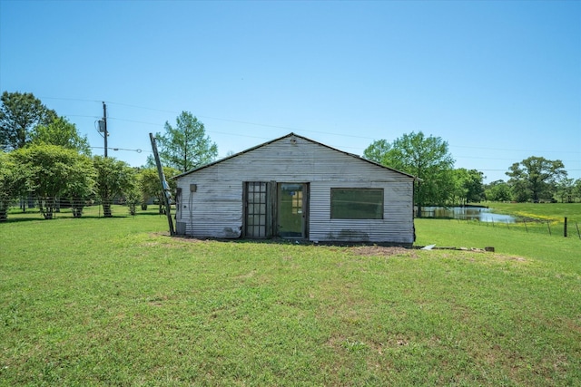 rear view of property featuring fence and a yard