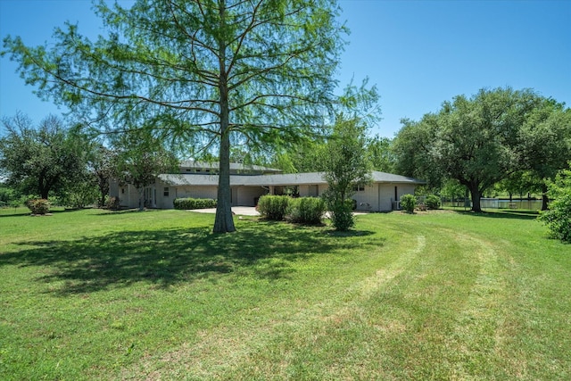 view of yard featuring fence and driveway
