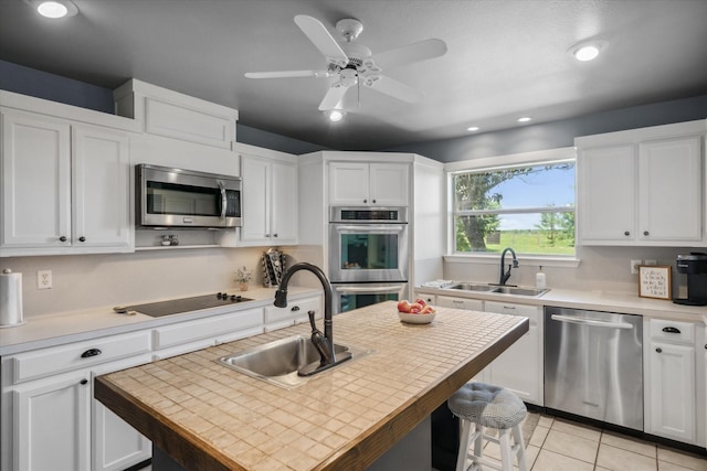 kitchen with stainless steel appliances, white cabinets, and a sink
