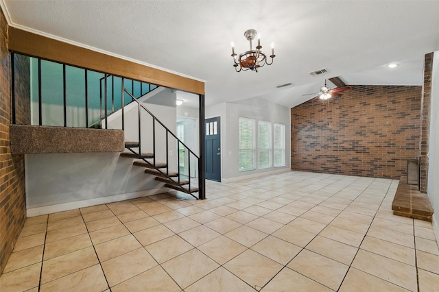 interior space with visible vents, lofted ceiling, brick wall, and stairway