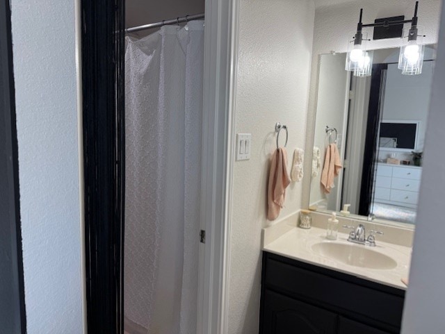 3609 S Texas Dr, Sachse, TX 75048 - bathroom with vanity, a textured wall, and a shower with curtain