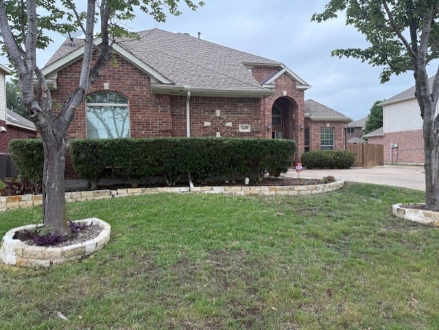 3609 S Texas Dr, Sachse, TX 75048 - view of front facade with brick siding, fence, a shingled roof, and a front yard