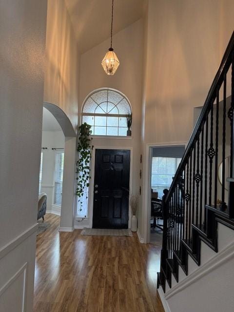 3609 S Texas Dr, Sachse, TX 75048 - foyer featuring wood finished floors, arched walkways, plenty of natural light, and a high ceiling