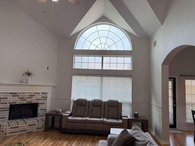 3609 S Texas Dr, Sachse, TX 75048 - living area with ceiling fan, a brick fireplace, arched walkways, high vaulted ceiling, and wood finished floors