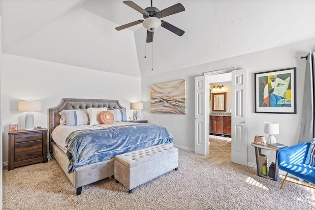carpeted bedroom with a ceiling fan, ensuite bath, vaulted ceiling, and baseboards