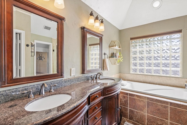 bathroom featuring lofted ceiling, visible vents, double vanity, and a sink