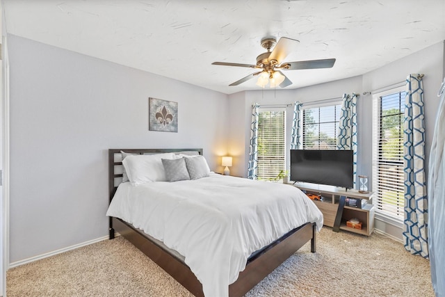 bedroom featuring light colored carpet, ceiling fan, and baseboards