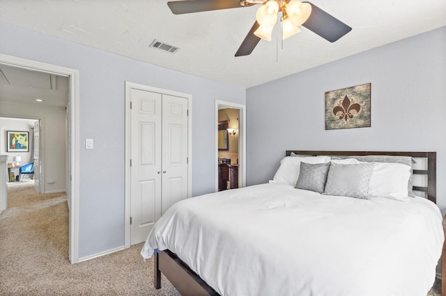 bedroom with light colored carpet, ceiling fan, visible vents, a closet, and attic access