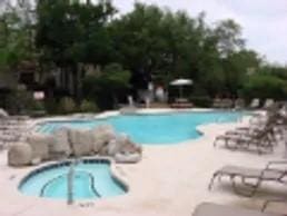 pool with a patio and an in ground hot tub
