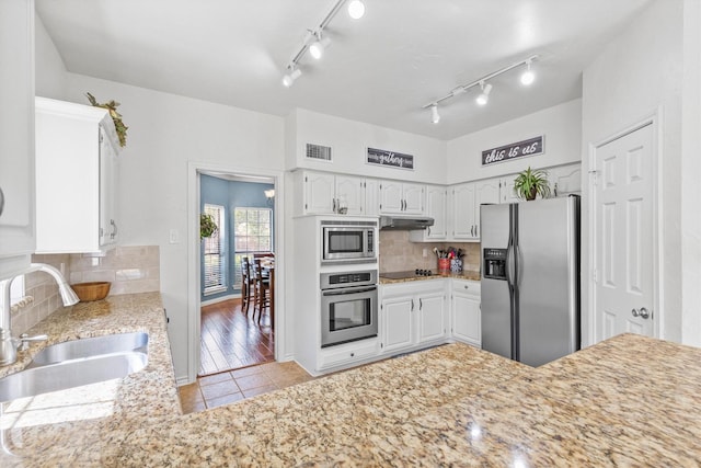 kitchen featuring stainless steel appliances, backsplash, a sink, visible vents, and light tile patterned flooring