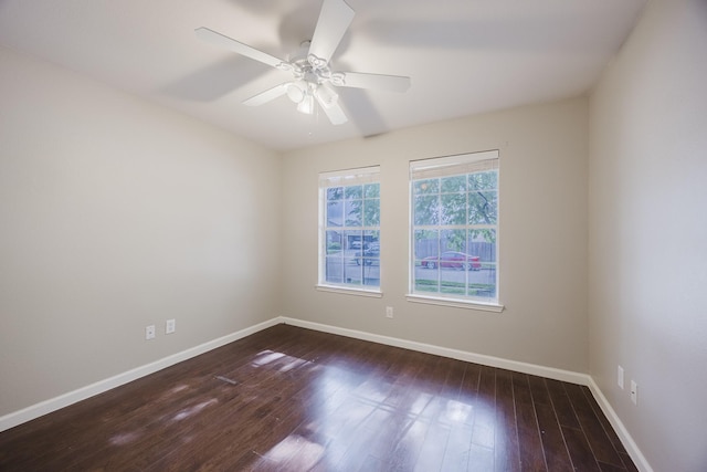 empty room with wood finished floors, a ceiling fan, and baseboards