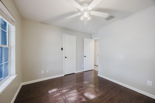 unfurnished room with baseboards, visible vents, and wood finished floors