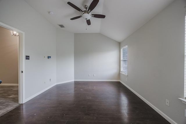 spare room featuring hardwood / wood-style flooring, visible vents, baseboards, vaulted ceiling, and a ceiling fan
