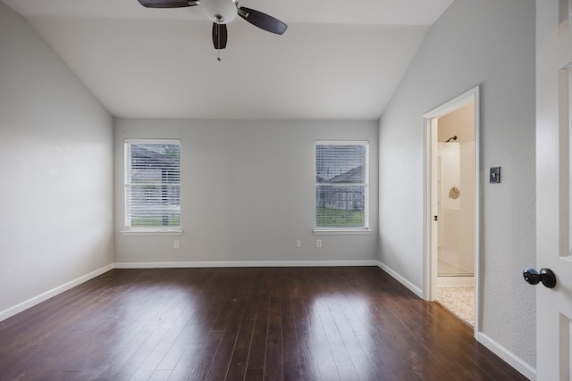 empty room featuring a ceiling fan, baseboards, vaulted ceiling, and dark wood finished floors