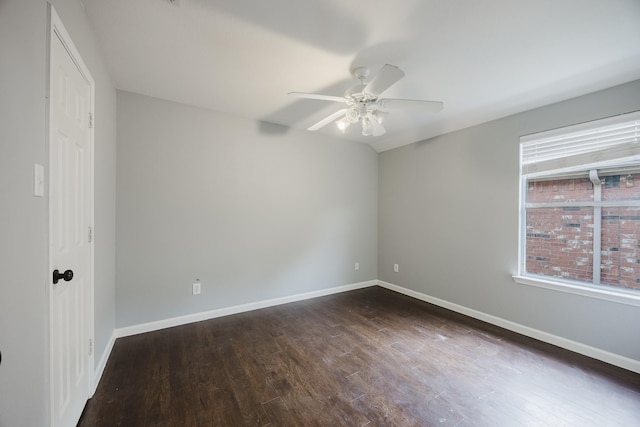 empty room with a ceiling fan, dark wood-style flooring, and baseboards