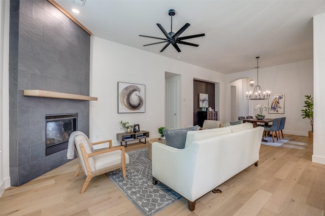 1823 Bell Ct, Van Alstyne, TX 75495 - living area with light wood-type flooring, a fireplace, ceiling fan, arched walkways, and recessed lighting