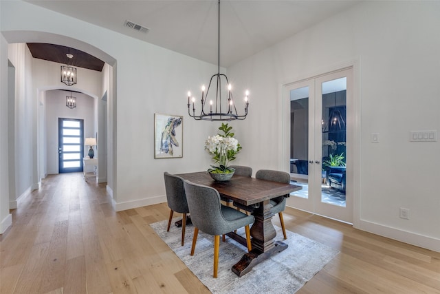 1823 Bell Ct, Van Alstyne, TX 75495 - dining area featuring french doors, a chandelier, arched walkways, and light wood finished floors