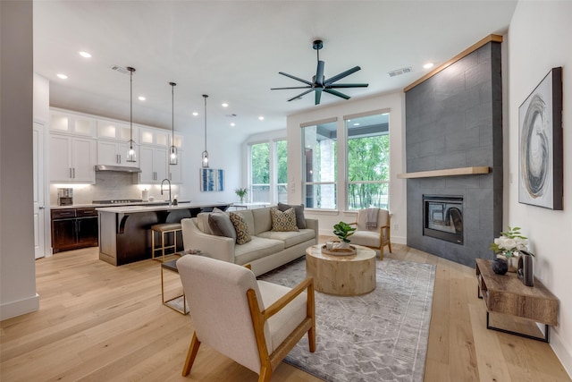 1823 Bell Ct, Van Alstyne, TX 75495 - living area featuring ceiling fan, light wood finished floors, a tiled fireplace, and recessed lighting