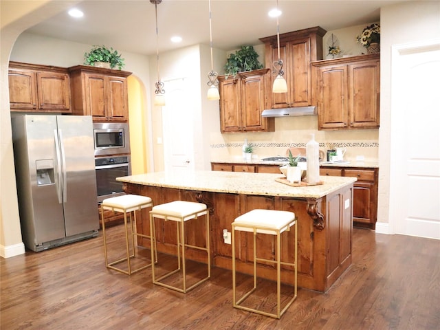 1852 Audubon Pond Way, Allen, TX 75013 - kitchen with appliances with stainless steel finishes, arched walkways, dark wood finished floors, brown cabinets, and under cabinet range hood