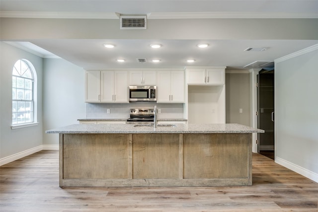 kitchen with baseboards, appliances with stainless steel finishes, white cabinetry, and a sink