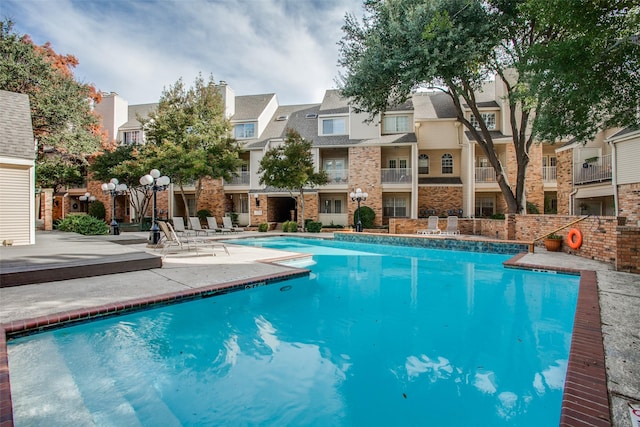 pool with a patio and a residential view