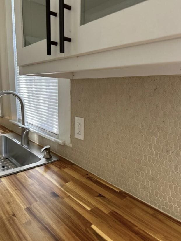 room details with wallpapered walls, butcher block countertops, and a sink