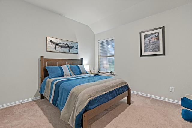 carpeted bedroom with baseboards and lofted ceiling
