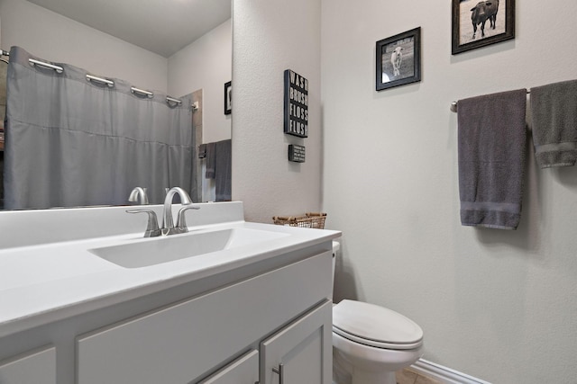 full bath featuring toilet, curtained shower, a textured wall, and vanity