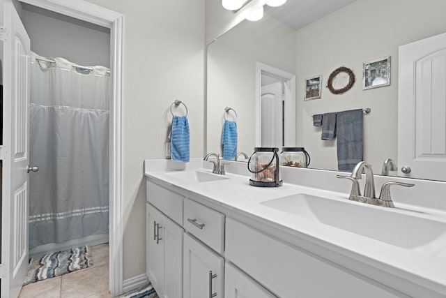 full bathroom with double vanity, a sink, and tile patterned floors