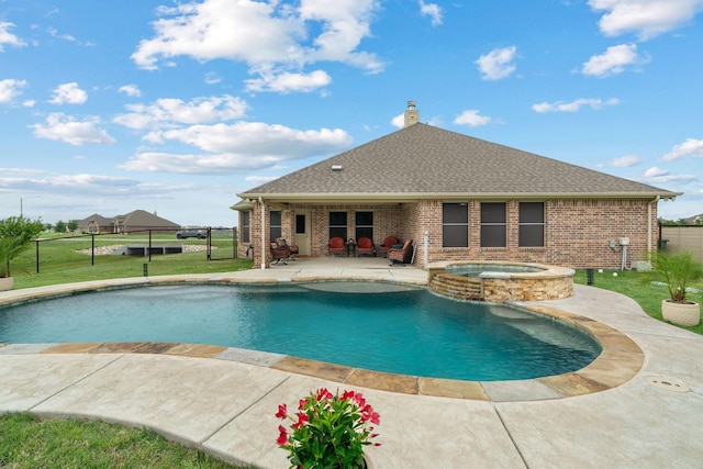 view of pool with a patio, a yard, a pool with connected hot tub, and fence