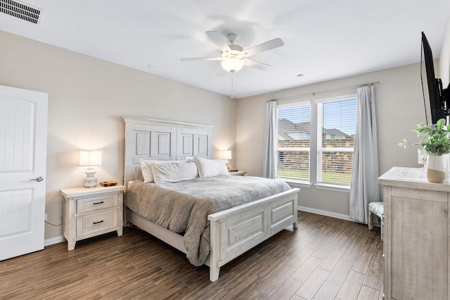 bedroom with visible vents, a ceiling fan, dark wood finished floors, and baseboards