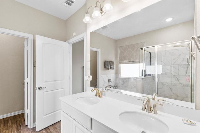 bathroom with wood finished floors, visible vents, a shower stall, and a sink