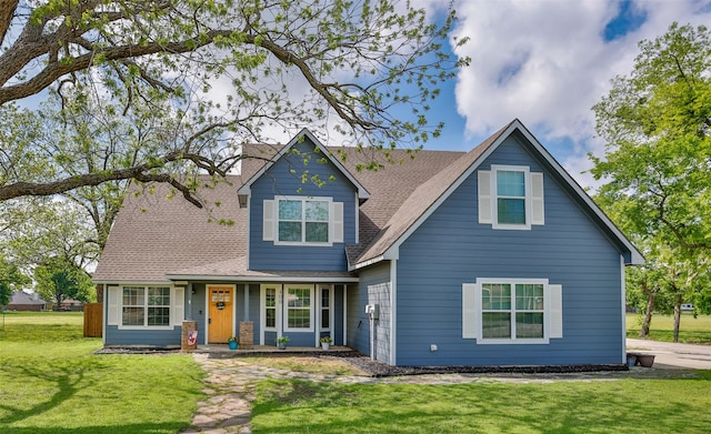 view of front facade featuring a chimney, a shingled roof, and a front yard