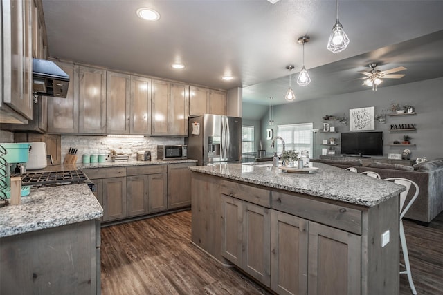 kitchen with decorative backsplash, a sink, dark wood-type flooring, range hood, and stainless steel fridge