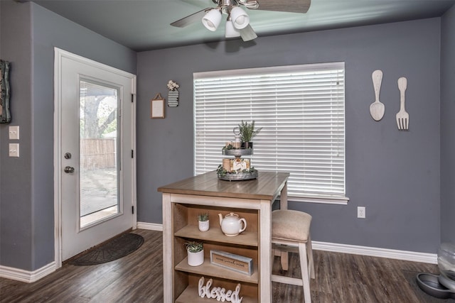 dining space with dark wood-style flooring, a ceiling fan, and baseboards