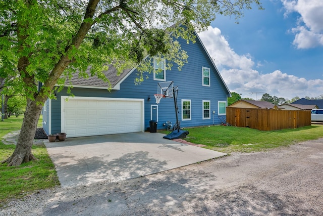 view of home's exterior with a garage, concrete driveway, fence, and a yard